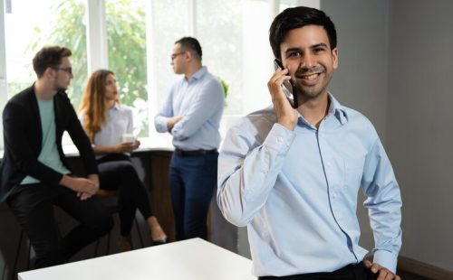 smiling-manager-talking-mobile-phone_1262-16506